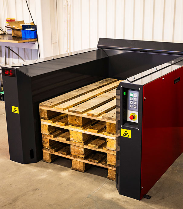 Red S-size electric PalletMaster® dispenser with four wooden pallets inside