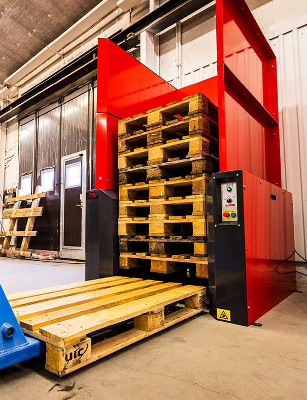 Wooden pallet ready to be stacked with pallet jack into a PalletMaster® dispenser underneath an existing stack